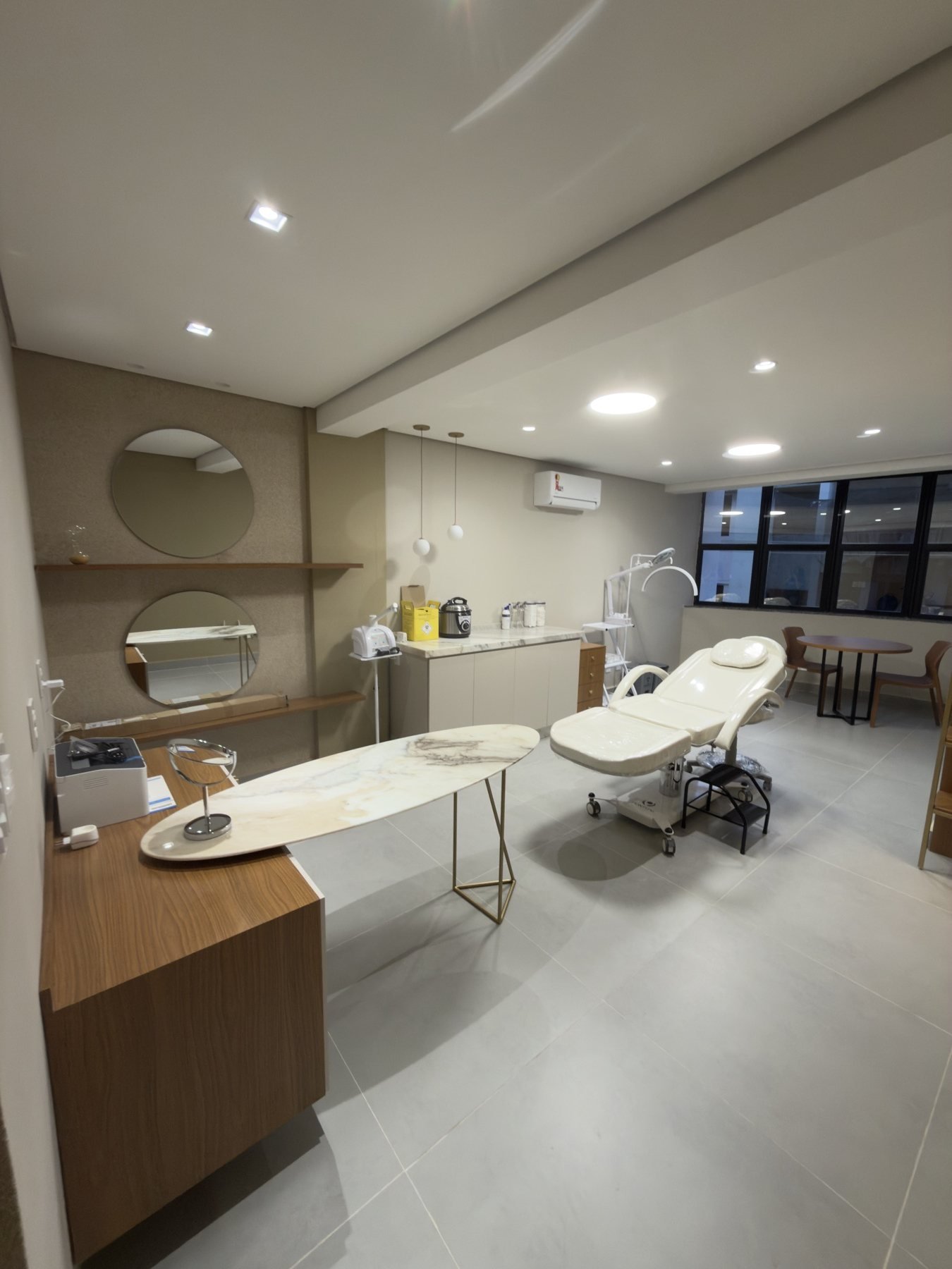 Sala de atendimento da clínica Isa de Paula, com maca e marcenaria clara
